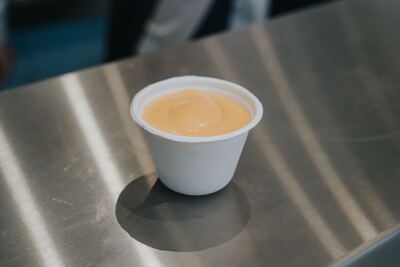Cup of house-made mayo on the stainless steel counter