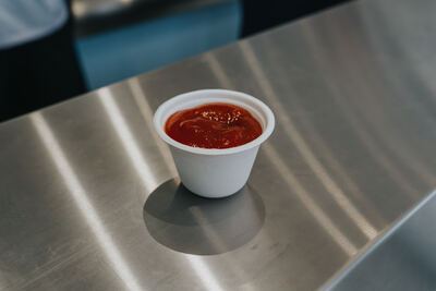 Cup of ketchup on the stainless steel counter